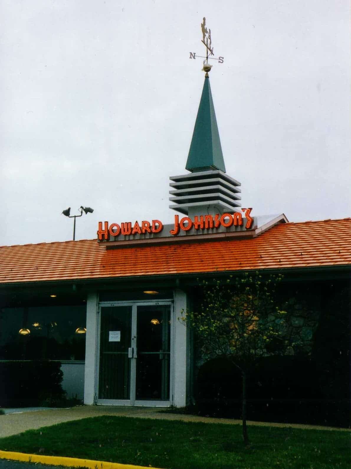 Entrance of a Howard Johnson’s restaurant with an orange roof and a teal spire, photographed in 1999