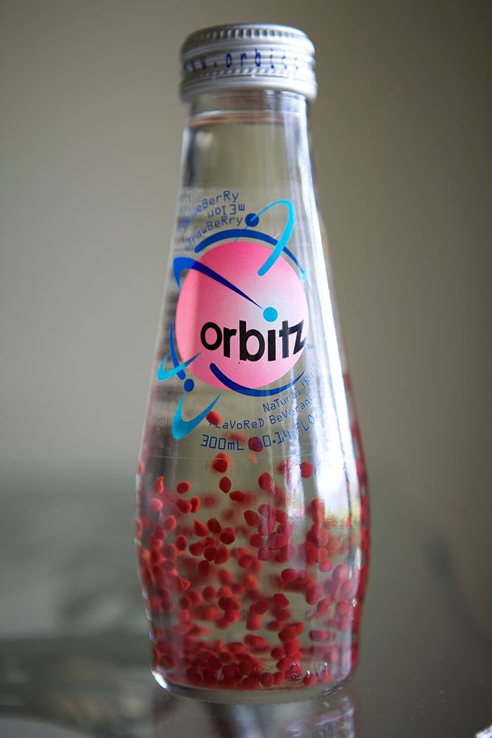 An Orbitz bottle with red gel balls settled at the bottom